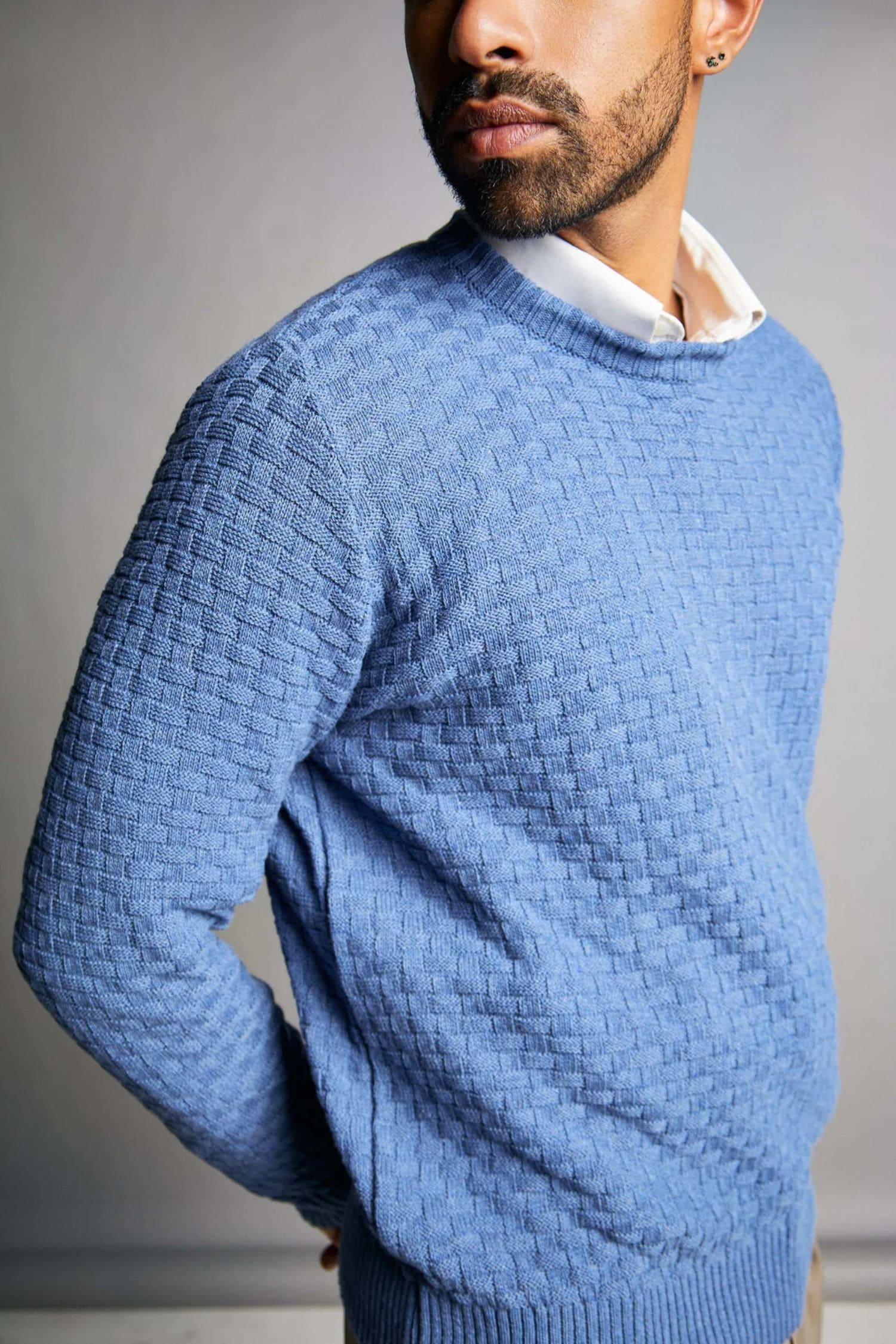 Hombre con suéter tejido azul de punto y camisa blanca, moda masculina elegante.